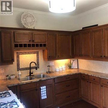 London apartment for rent - A kitchen with brown cabinets and a tile backsplash.