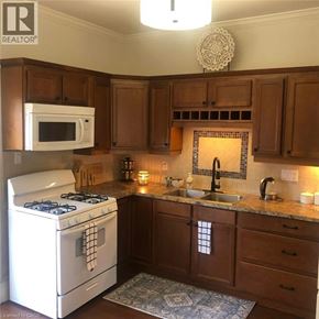 London apartment for rent - A kitchen with a white stove and a white microwave.