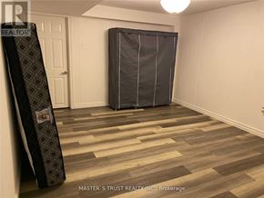 Toronto (Newtonbrook East) apartment for rent - A room with a wooden floor and a large black object leaning against the wall.