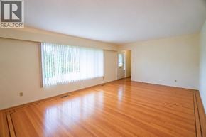 Vancouver apartment for rent - A room with wooden floors and a window with blinds.
