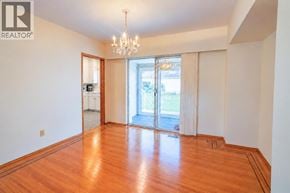 Vancouver apartment for rent - A large empty room with wooden floors and a chandelier.