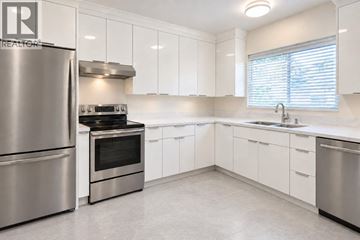 Vancouver apartment for rent - A modern kitchen with white cabinets and stainless steel appliances.
