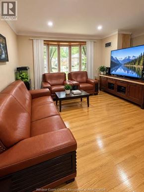 Windsor apartment for rent - A living room with a brown leather couch and a flat screen TV.