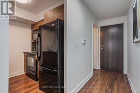 Toronto (Agincourt South-Malvern West) condo for rent - A black refrigerator in a kitchen with wooden floors.
