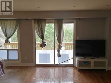 Markham (Unionville) townhouse for rent - A living room with a television and sliding glass doors.