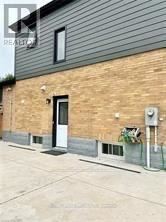 Niagara Falls (Hospital) apartment for rent - A brick house with a black door and a small window.