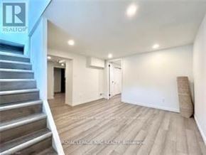 Niagara Falls (Hospital) apartment for rent - A spacious room with wooden flooring and a staircase on the left side.
