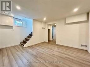 Niagara Falls (Hospital) apartment for rent - A spacious room with wooden flooring and a staircase leading to another room.