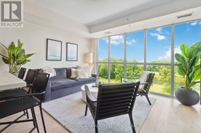 Niagara Falls (Oldfield) condo for rent - A living room with a couch, chairs, and a table with a vase of flowers on it.