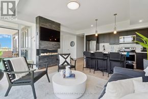 Niagara Falls (Oldfield) condo for rent - A modern living room with a fireplace and a dining area.