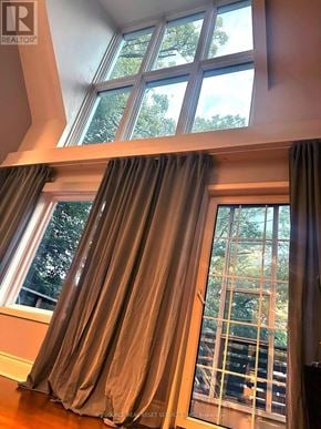 Toronto (The Beaches) apartment for rent - A window with a view of trees and a balcony with a railing.