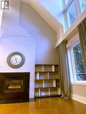 Toronto (The Beaches) apartment for rent - A fireplace with a clock above it in a room.