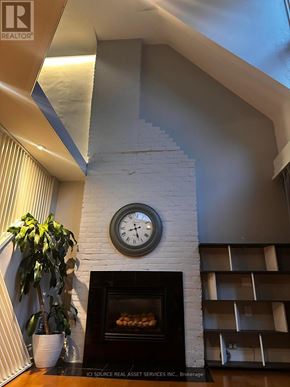 Toronto (The Beaches) apartment for rent - A fireplace with a clock above it in a room.
