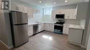 Sudbury apartment for rent - A modern kitchen with a stainless steel refrigerator and wooden flooring.