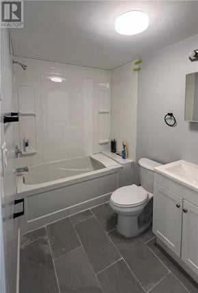Sudbury apartment for rent - A kitchen with white cabinets and a stove top oven.