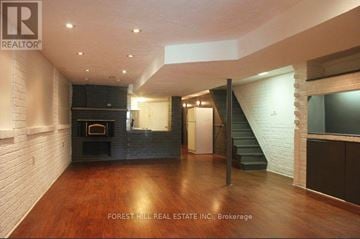 Toronto (Little Portugal) apartment for rent - A spacious living room with wood flooring and a staircase.