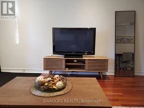 Toronto (Danforth Village-East York) apartment for rent - A modern living room with a flat screen TV and a wooden cabinet.