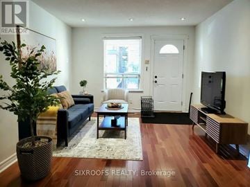 Toronto (Danforth Village-East York) apartment for rent - A living room with a blue couch and a wooden floor.