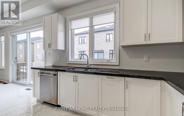 Georgina (Keswick South) apartment for rent - A kitchen with white cabinets and a black countertop.