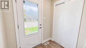 Ottawa townhouse for rent - A white door with a glass window is in a room with a wooden floor.