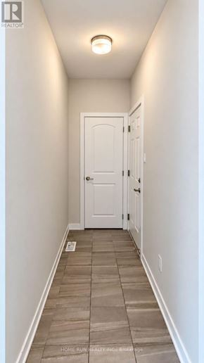 Ottawa townhouse for rent - A hallway with a white door and tiled floor.