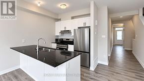 Ottawa townhouse for rent - A modern kitchen with a black countertop and stainless steel appliances.