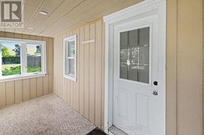 Ottawa apartment for rent - A room with a white door and a window with a view of a green area outside.