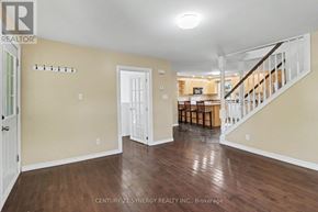 Ottawa apartment for rent - A spacious room with wooden floors and a staircase leading to another room.