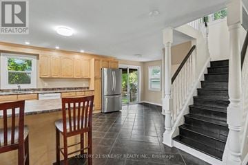 Ottawa apartment for rent - A kitchen with wooden cabinets and a black staircase.