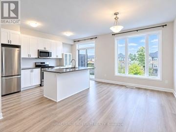 Ottawa townhouse for rent - A spacious kitchen with white cabinets and a large island.