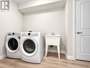 Ottawa townhouse for rent - A laundry room with a washer and dryer and a small table.
