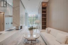 Burlington (Brant) condo for rent - A modern living room with a white sofa and a marble floor.