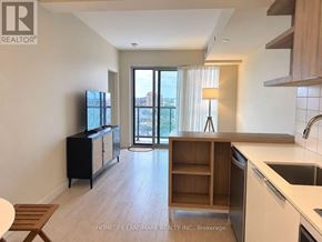 Toronto (Flemingdon Park) condo for rent - A kitchen with a sink, stove, and cabinets with a sliding glass door leading to a balcony.