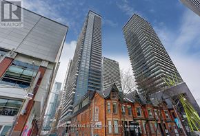 Toronto (Waterfront Communities) condo for rent - A cityscape with a mix of modern and traditional architecture, with a clear sky above.