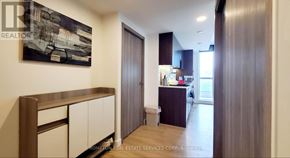 Toronto (Waterfront Communities) condo for rent - A room with a brown and white cabinet and a painting on the wall.