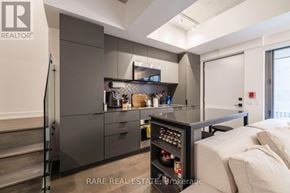 Toronto (Moss Park) townhouse for rent - A modern kitchen with a stainless steel refrigerator and a glass shelf.