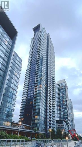 Toronto (Waterfront Communities) condo for rent - A cityscape with tall buildings and a cloudy sky.
