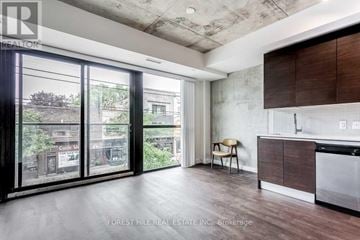 Toronto (South Riverdale) condo for rent - A modern kitchen with a dining chair and a view of the city.