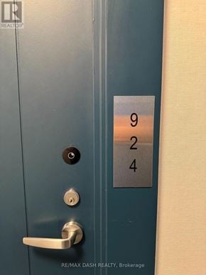 Oshawa (Windfields) condo for rent - A blue door with a silver handle and a sign with the numbers 924 on it.