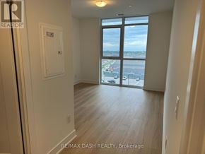 Oshawa (Windfields) condo for rent - A room with a view of the city through a large window.