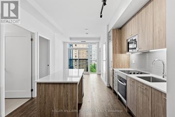 Toronto (East End-Danforth) condo for rent - A modern kitchen with wooden cabinets and a white countertop.