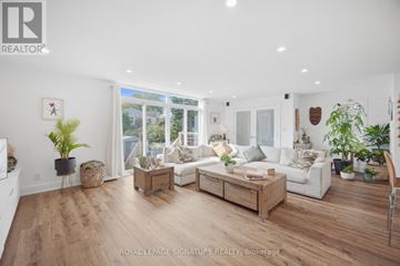 Toronto (O'connor-Parkview) apartment for rent - A well-lit, spacious living room with a white sofa set and wooden flooring.