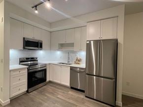 Surrey apartment for rent - A kitchen with a stainless steel refrigerator, oven, and microwave.