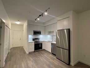 Surrey apartment for rent - A kitchen with a refrigerator, stove, and microwave.