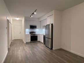 Surrey apartment for rent - A kitchen with a refrigerator, microwave, and oven.