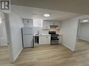 Markham (Milliken Mills West) apartment for rent - A kitchen with white cabinets and a refrigerator.
