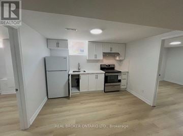 Markham (Milliken Mills West) apartment for rent - A kitchen with white cabinets and a refrigerator.
