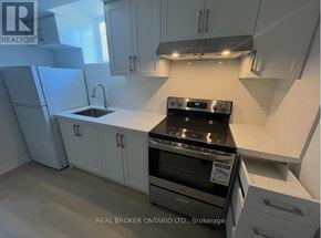 Markham (Milliken Mills West) apartment for rent - A kitchen with white cabinets and a black stove top oven.