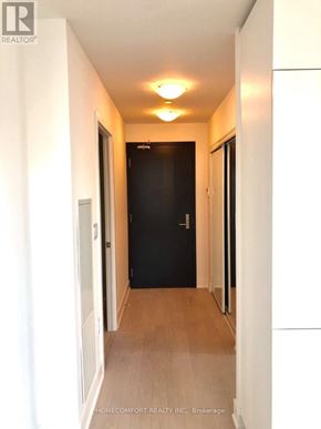 Toronto (Bay Street Corridor) condo for rent - A long hallway with a black door at the end.