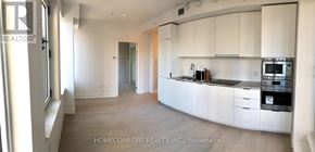 Toronto (Bay Street Corridor) condo for rent - A realtor photo of a white kitchen with a black stove.